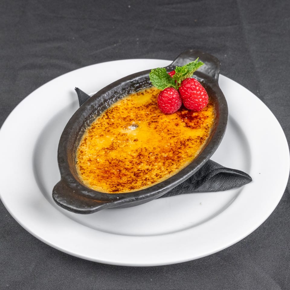 Creme brulee topped with raspberries and mint.